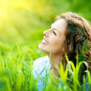 lächelnde Frau im Gras- sich selbst verzeihen