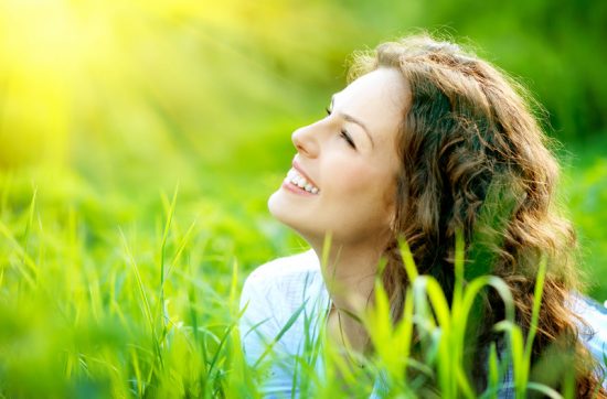lächelnde Frau im Gras- sich selbst verzeihen